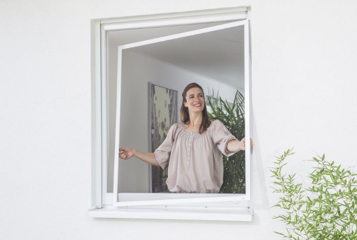 Frau hängt Neher Spannrahmen ein- oder aus. Einfache Bedienung ohne Werkzeug.