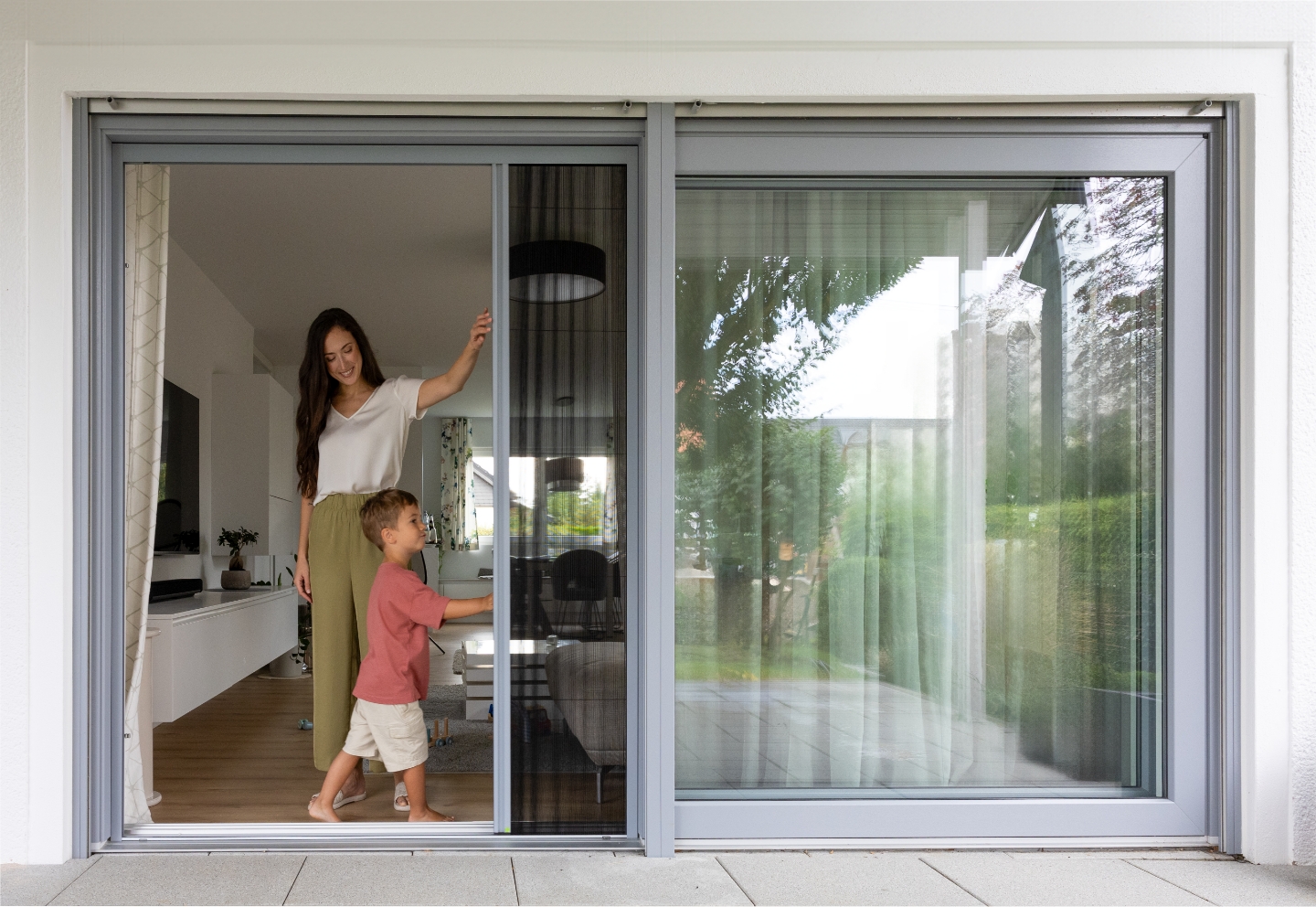 Neher Insektenschutz‑Plissee an der Terrassentür; kinderleichte Einhandbedienung, leichtgängige Laufleiste und elegante Faltstruktur für freie Sicht.